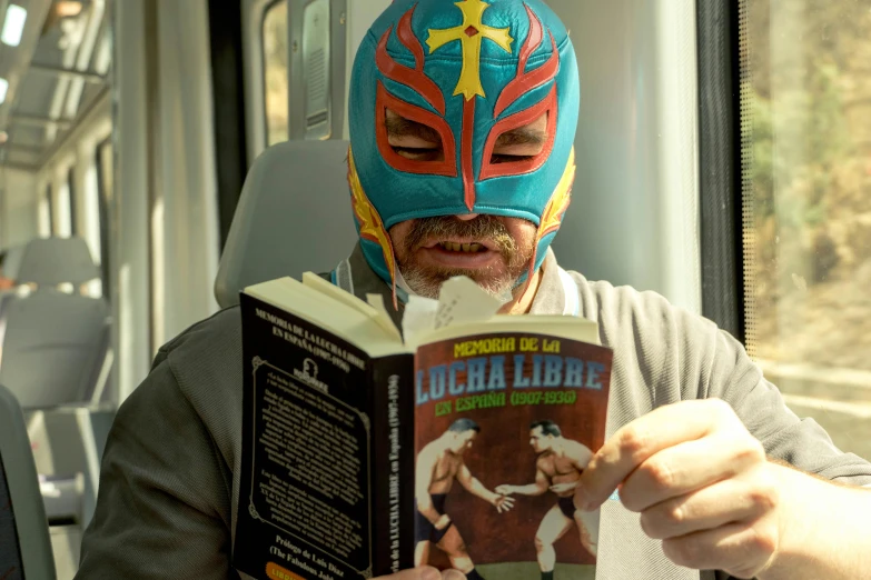 the man has a colorful mask on reading a book