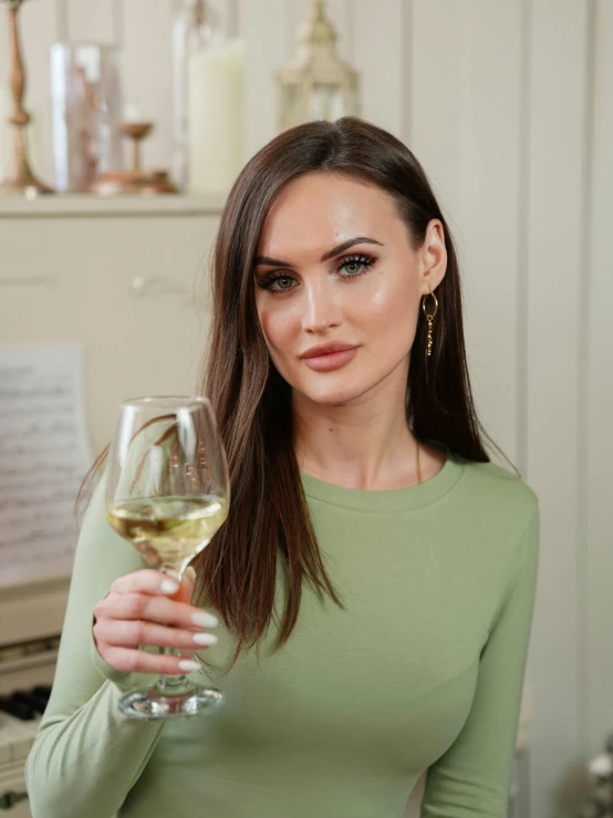 a woman is holding a wine glass in one hand