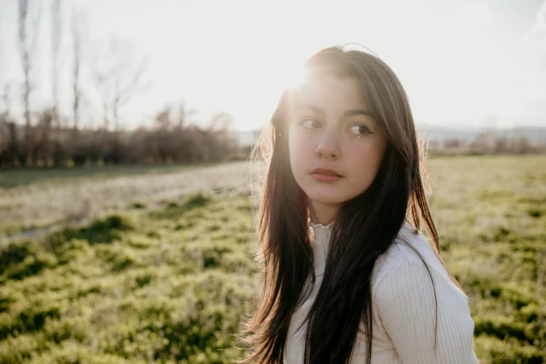 a woman is standing in a large field