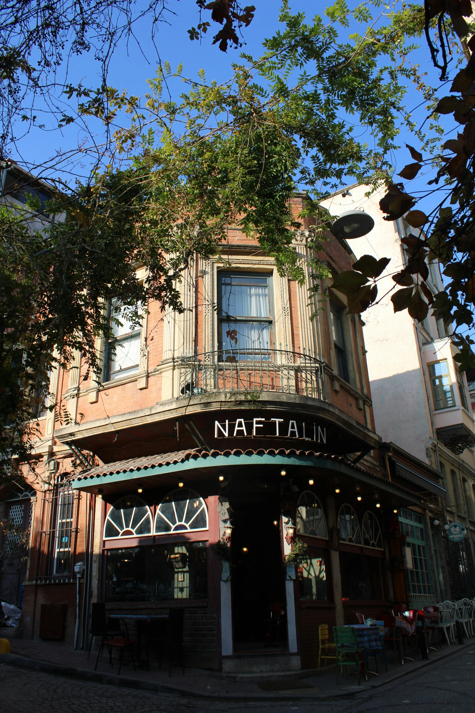 a tree covered building with a restaurant on the front and second story