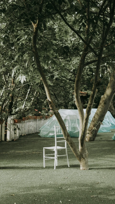 an old fashioned white chair sits in a garden