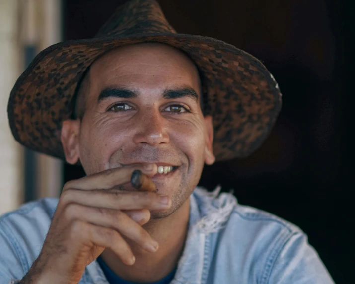 a man is smiling while smoking a cigarette