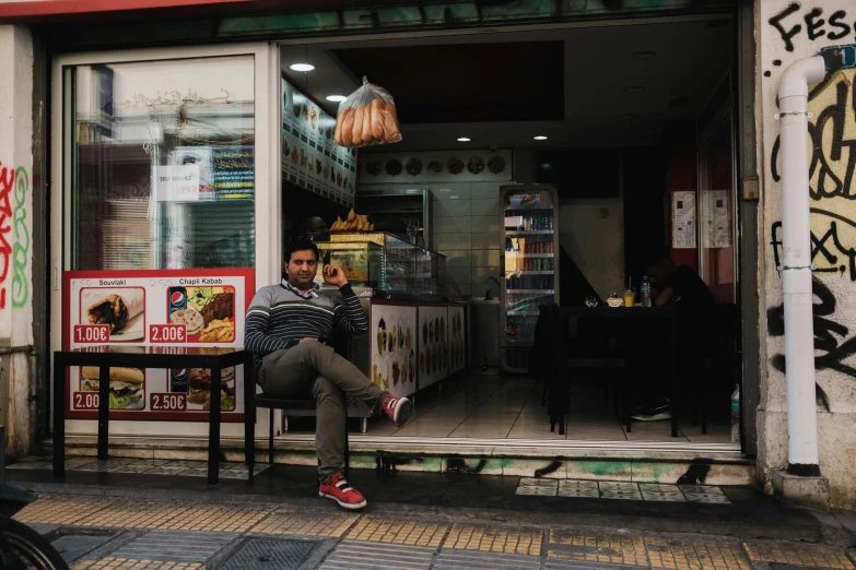 a man sitting outside of a fast food restaurant