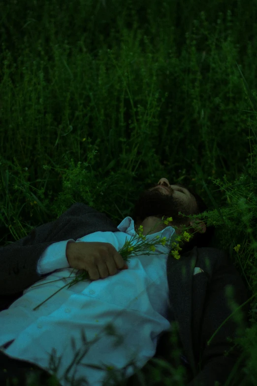 a man laying on the ground with green grass around him