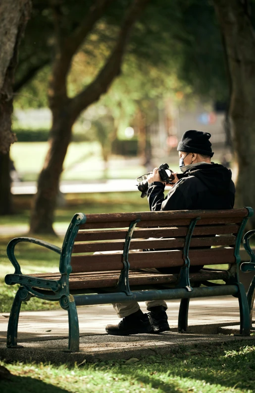 an elderly person sitting on a bench with a hat and gloves