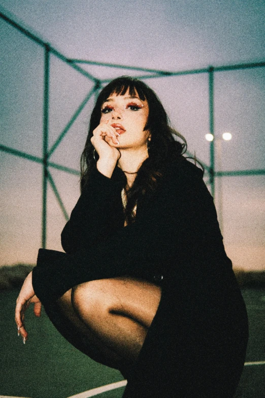 woman sitting on the ground with her hand on her chin looking up