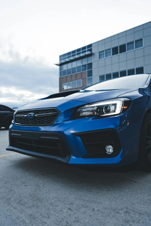 a blue subarunt parked in front of a building