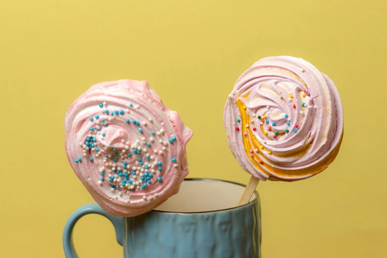 a blue mug holds two different types of pink frosted candy