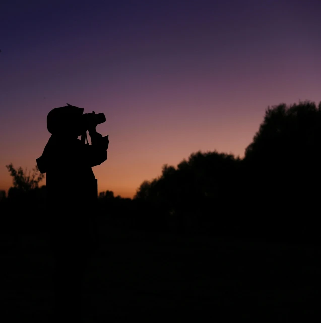 the silhouette of a pographer at sunset