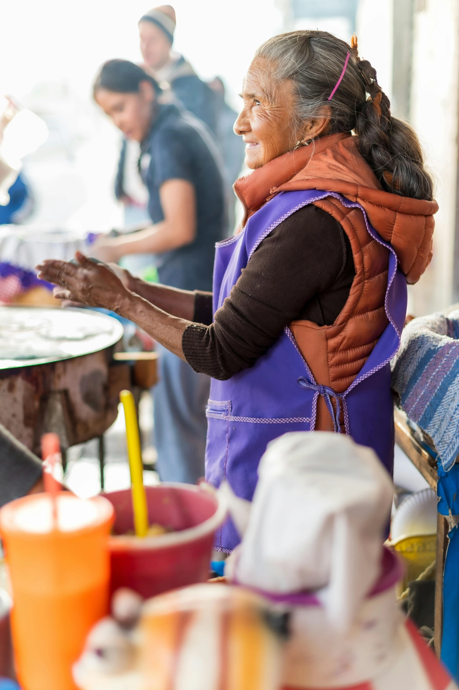 a woman standing in front of tables selling items