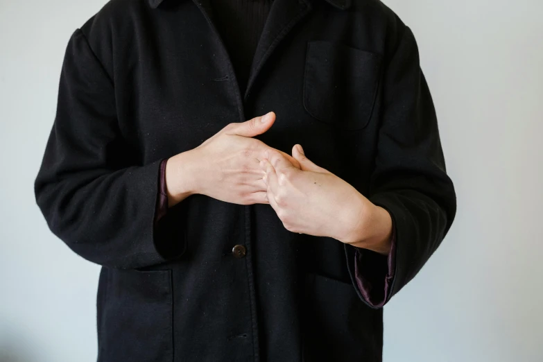 a person standing with their hands folded in the air