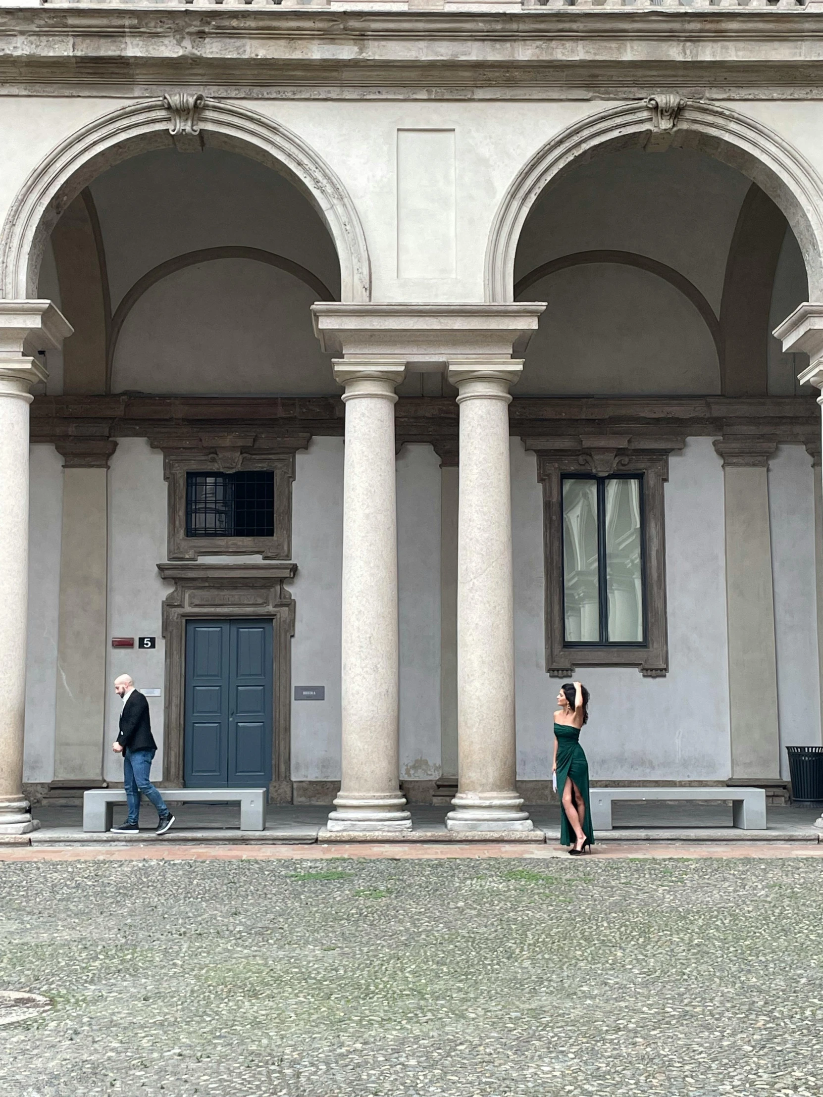 two men and a woman walking by an old building