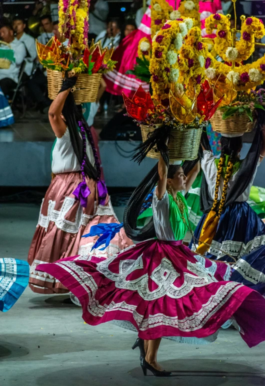 several women carrying large vases full of flowers