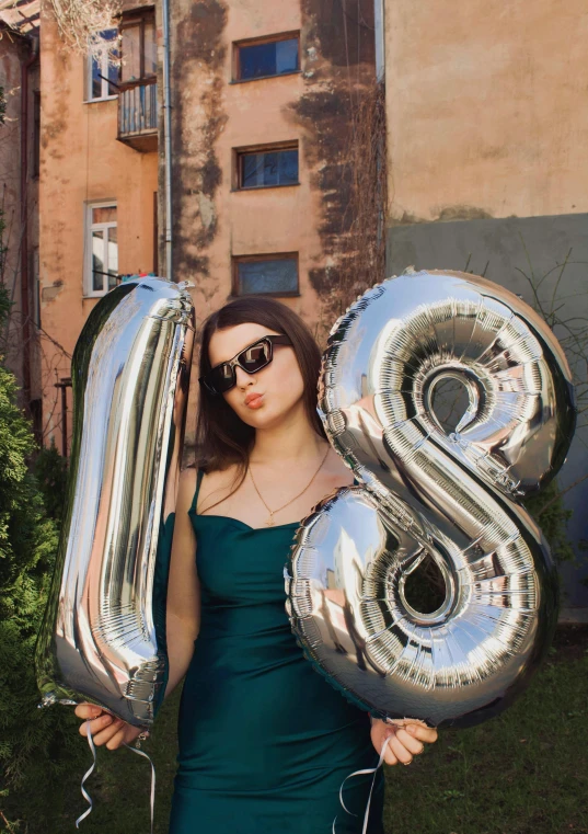 a girl is holding balloons that are 33 and number