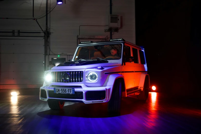 an orange and blue light in the background with a white jeep inside