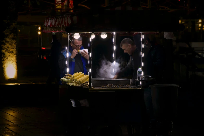 two men working at a restaurant while the light is on