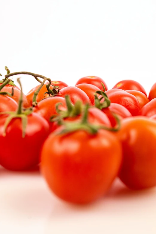 tomatoes on top of each other on white surface