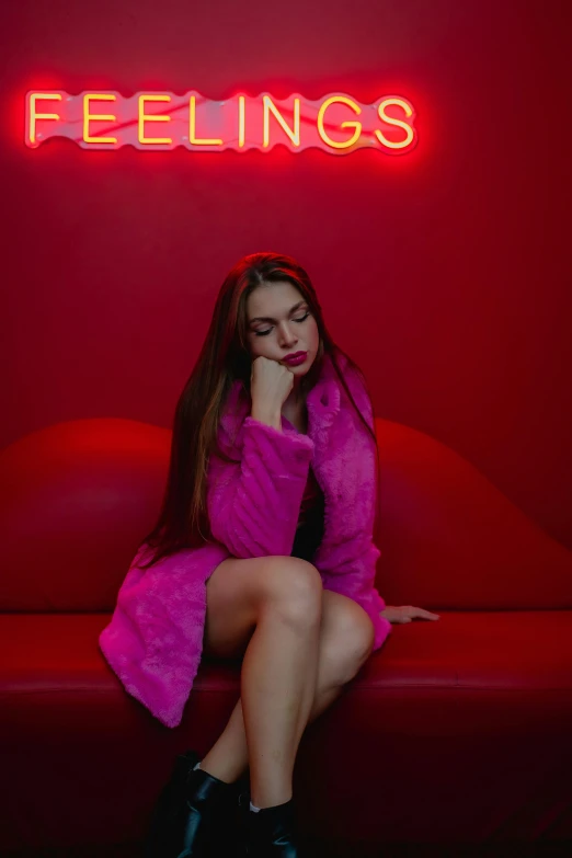 a girl sits on a red couch while she looks at the camera