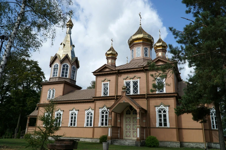 a brown and gold church with steeples in the background