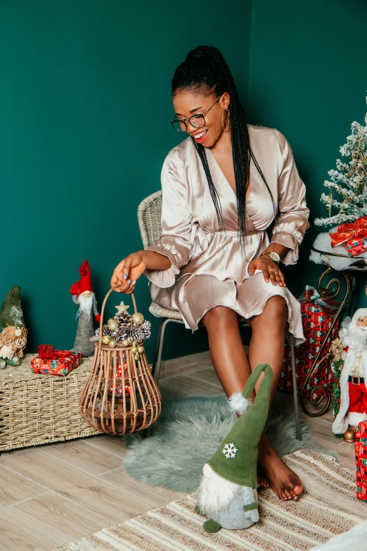 a woman with long hair sitting on a chair by some christmas decorations