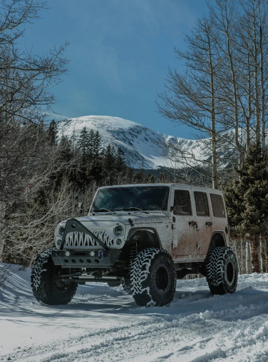 a jeep with a big tire is parked in the snow