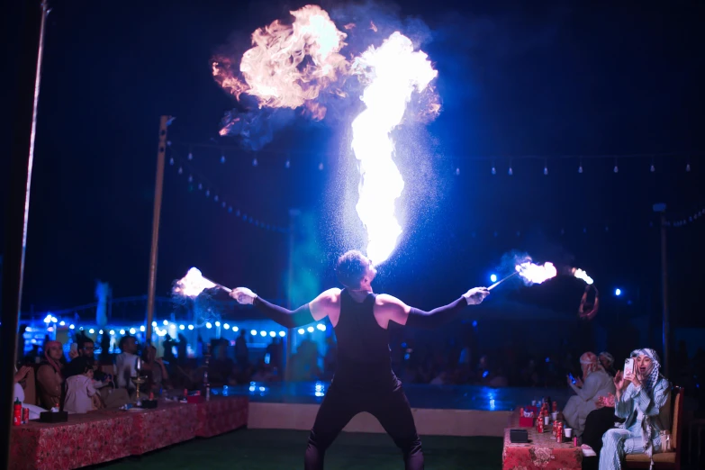 person juggling with fire while onlookers watch