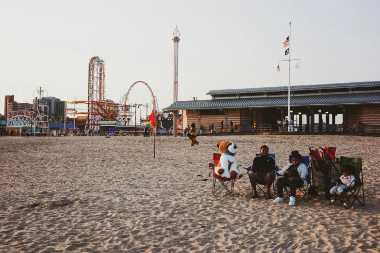 a group of people sitting in chairs on the beach