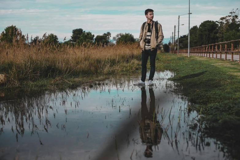 man walking away from camera into dle of water