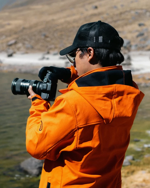 man looking through binoculars looking over a river