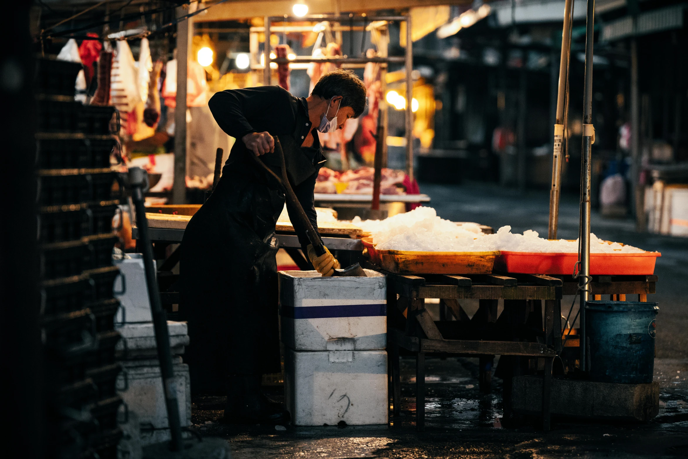 a person working on soing in an outdoor market