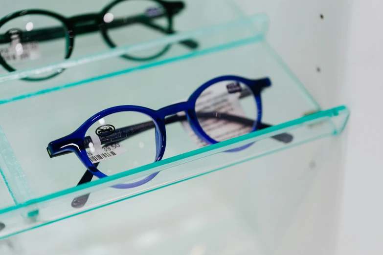 glasses are placed on display with clear glass shelves