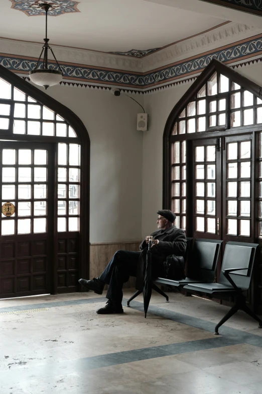 man sitting on bench in the middle of an open building