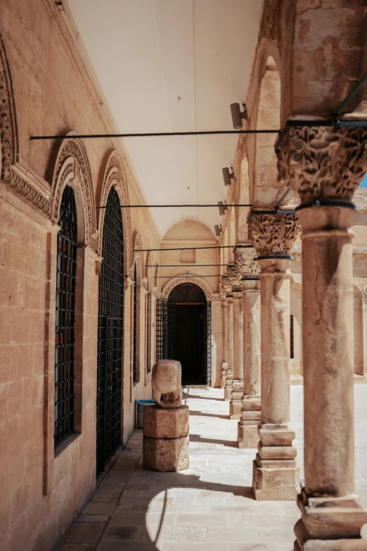 a long hallway that has pillars between it and a window