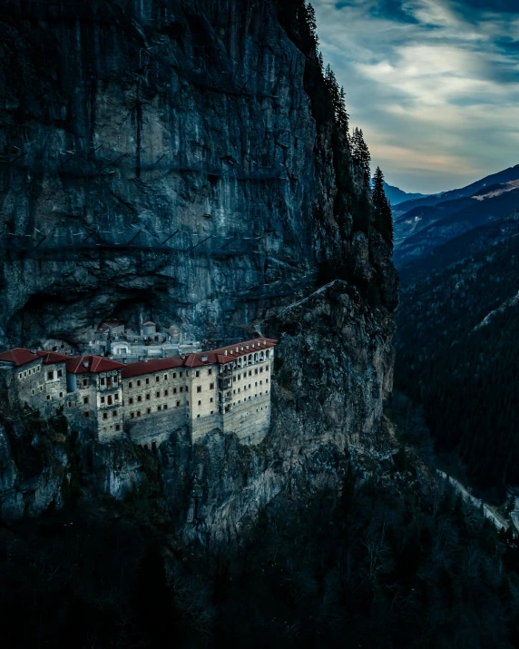 an old castle is nestled on top of the mountains