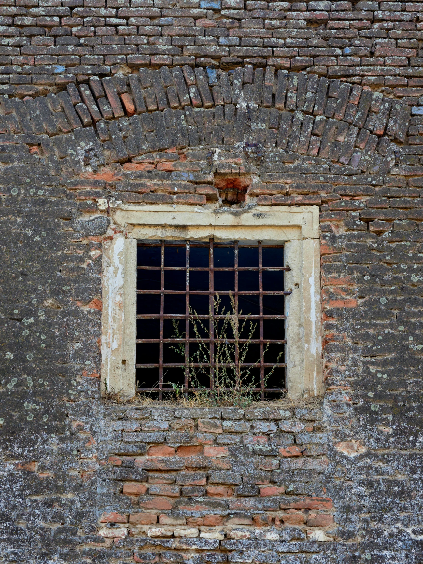 an old window sitting above a brick wall