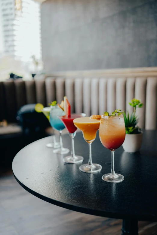 a line of martinis in front of a brown sofa