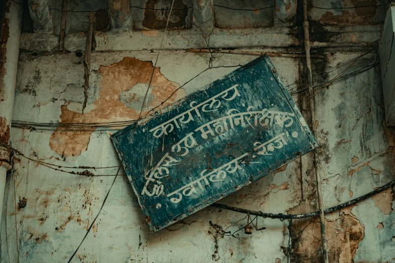 a blue sign that has graffiti on it and is lying on the ground