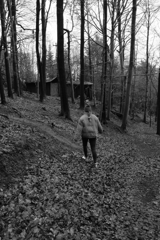 a black and white po of a man walking in the woods