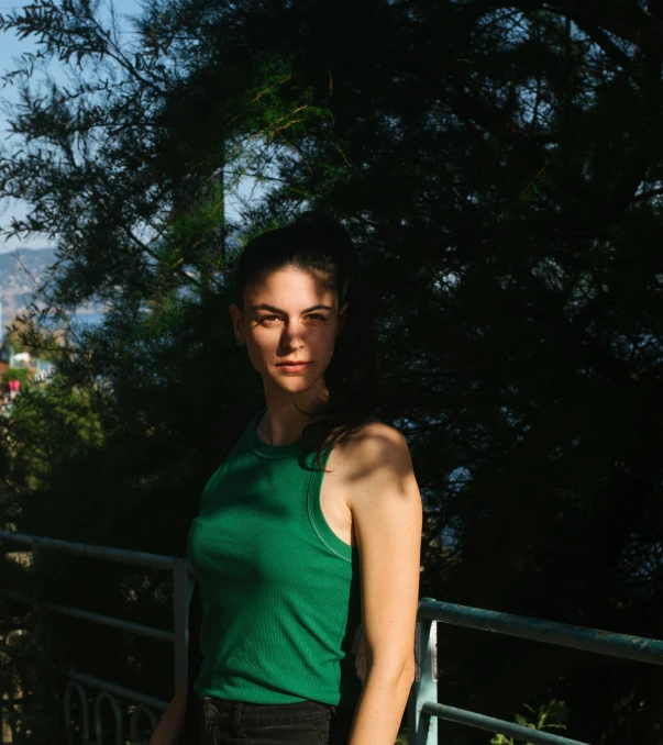 a woman in a green shirt and black shorts