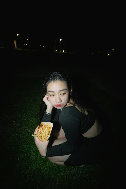 a young woman eating a snack in the dark