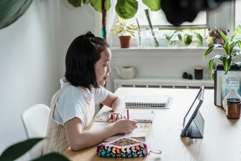 an image of a little girl sitting at a table