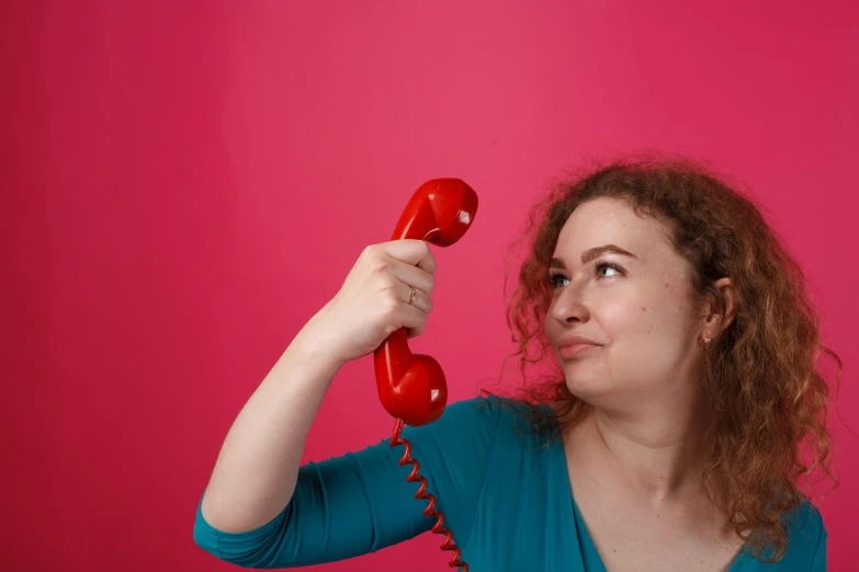 the woman is holding an old phone and making a face