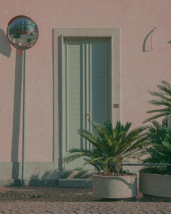 a tree near a very big door with a lamppost on it