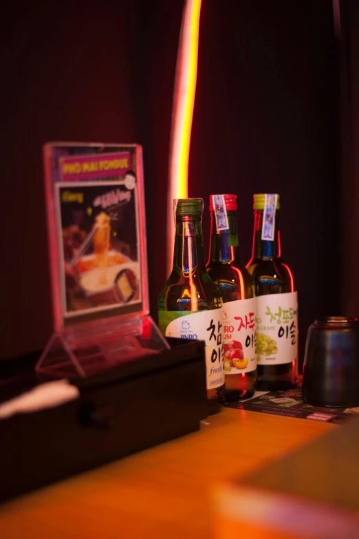 bottles of beer are on a table next to a box with a light on it