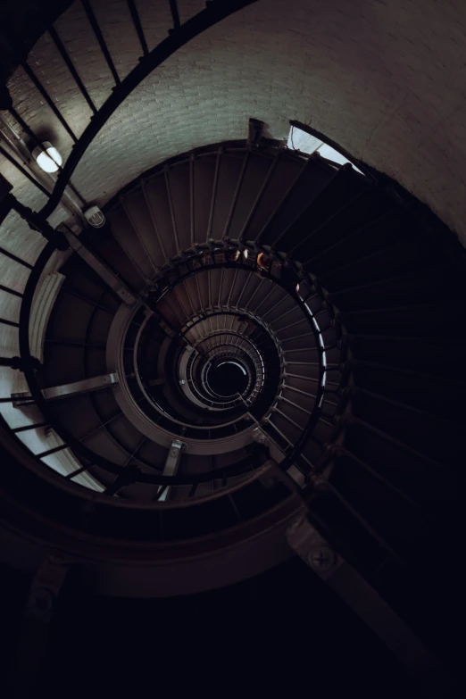 a spiral staircase with light shining in the corner