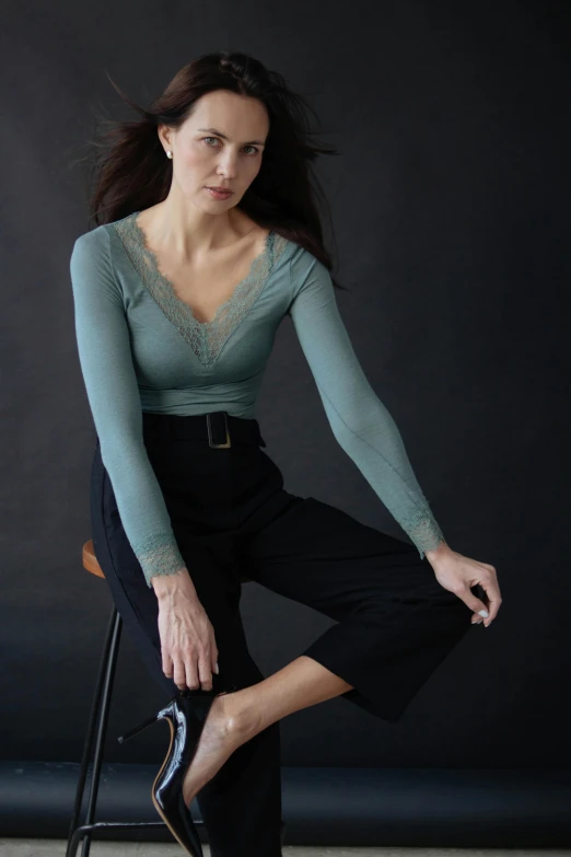 a woman posing for the camera next to a chair