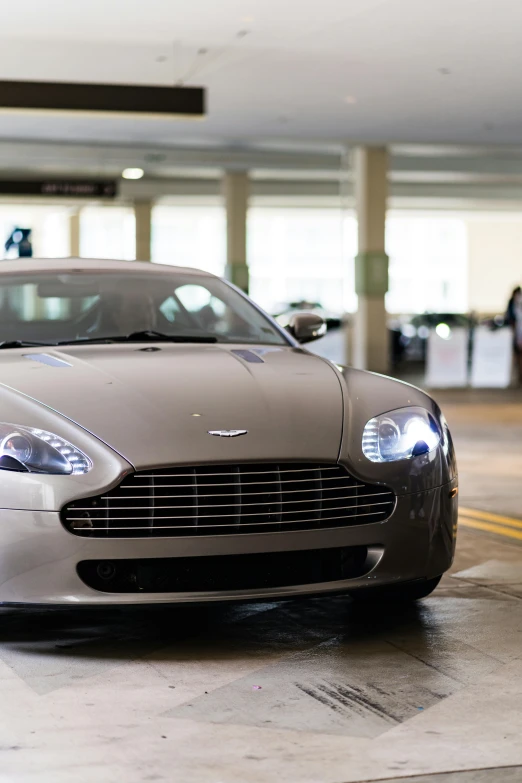 the front view of a silver car parked in a parking garage