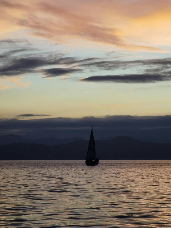 a boat traveling through a body of water with clouds