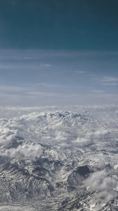 the view from an airplane of mountains in winter