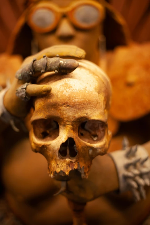 a human figure holding a fake skull in its hand